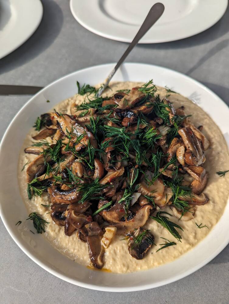 Fried mushrooms and dill piled on a bed of polenta